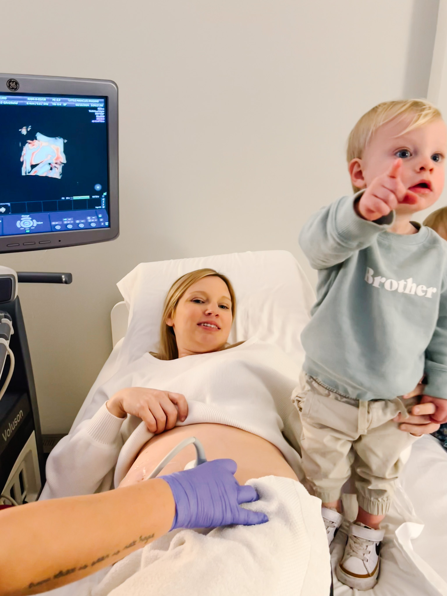 a little boy looks at ultrasound screen with his mom<br />

